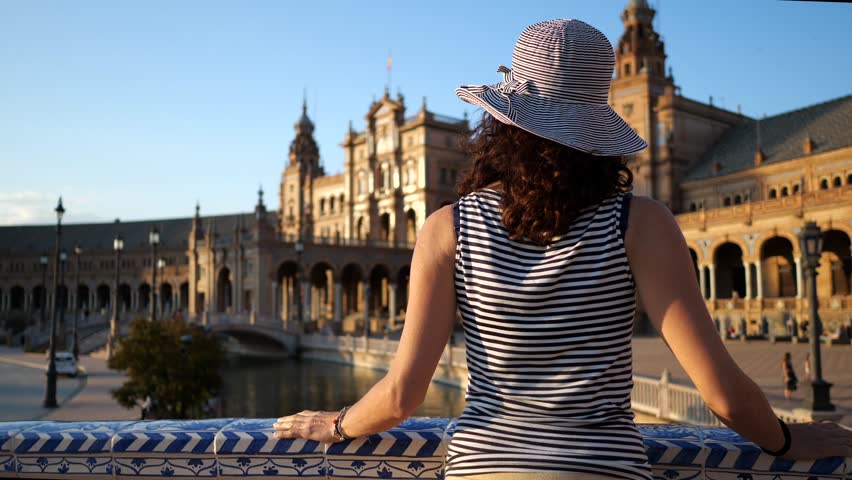 Woman admiring Plaza de Espana (Spain Square). Built on 1928, it is one example of the Regionalism Architecture mixing Renaissance and Moorish styles. Seville, Spain. Life style. Royalty-Free Stock Footage #1017010987