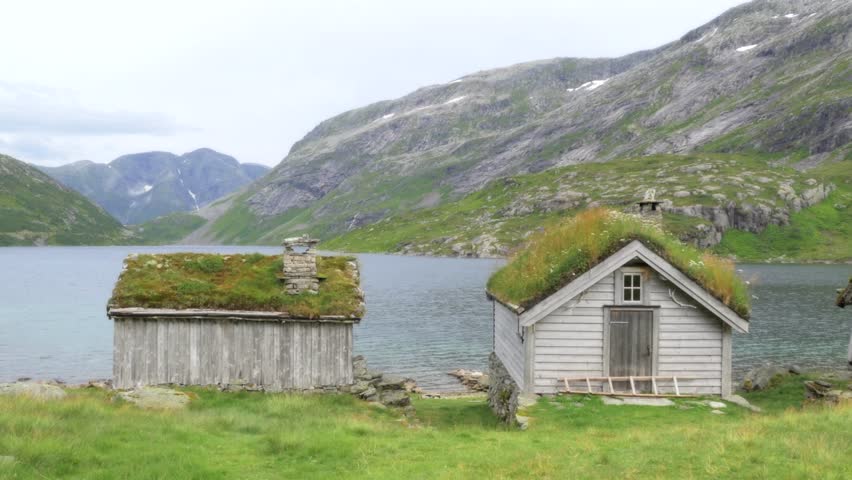 Cabin near the shore in the tranquility of the lake and mountains of Norway. 4k