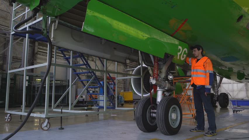 Engineer checks the operation of the hatch of the front landing gear of the aircraft.  Master repairs the engine of a passenger aircraft. Engineer checks the engine of the aircraft.  Royalty-Free Stock Footage #1017014140