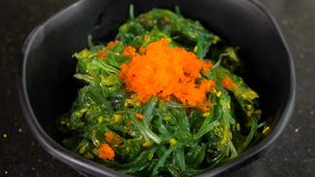 Motion video of Japanese fresh seaweed salad on black bowl in the restaurant