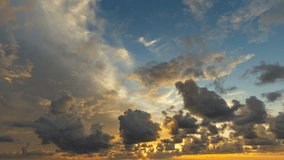 timelapse of clouds crossing the amazing sky over the sea or ocean at sunset. Sun rays emerge through the clouds. The clouds cross slowly from right to left and appear to be orange blue and purple.