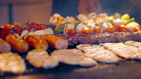 FullHD video - Local. Turkish street vendor turns kabobs. sausages. hamburgers and chicken breasts on a barbecue grill in preparation for a busy afternoon rush.