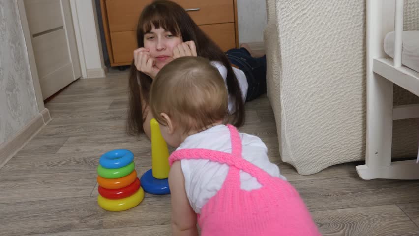 little daughter collects colorful designer, mom plays with child in nursery