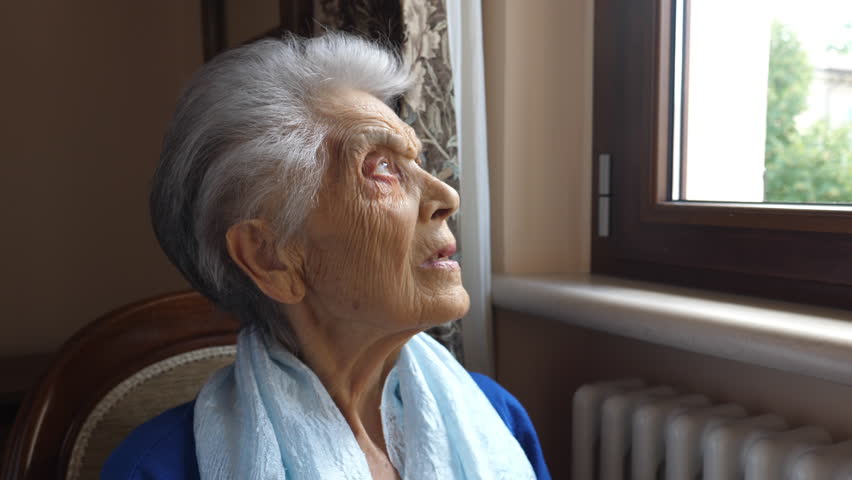 Portrait of caucasian elderly woman looking outside the window (senior adult 80+) | Shutterstock HD Video #1017025633