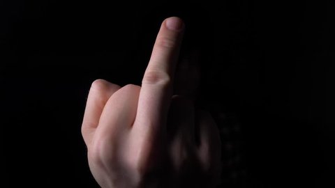 male Hand Showing Middle Finger out of the Darkness. 4K slow motion