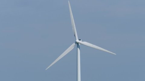 A close up film of a windmill. You only see the top of the windmill. The wicks turn in the wind. Windmill is wind energy. Footage in 4K.
