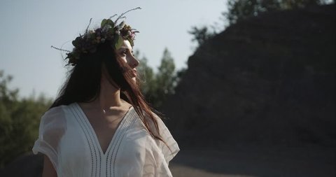 Forest nymph. Beautiful brunette woman dressed like a nymph walks before breathtaking mountain landscape Stock Video