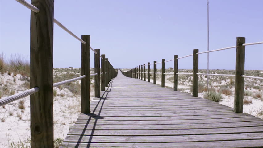 Tourists in footpath acess to Armona cost beach, one of the islands of Ria Formosa wetlands natural park, Algarve, southern Portugal.