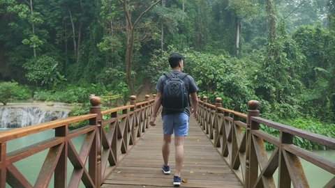 Hiker Walking On Wooden Bridge
