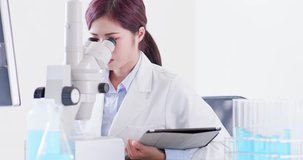 woman scientist use microscope and digital tablet in the laboratory