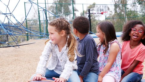 Elementary school kids spinning in a playground