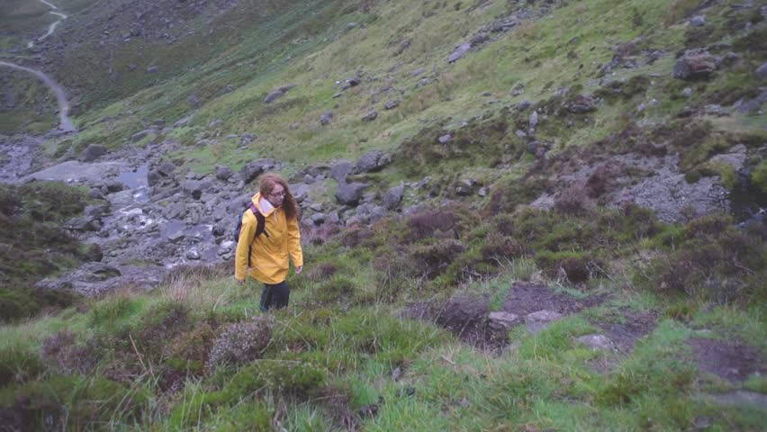 female hiking near the waterfall. Hiker looking at Mahon Falls in Ireland