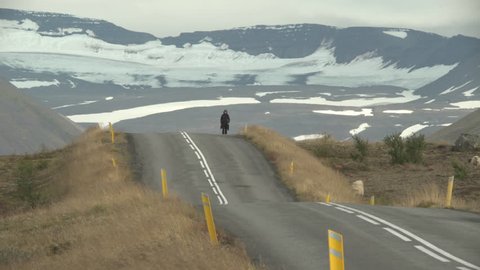 Girl walking alone on country road under snowy mountains, Holar Iceland.mov
