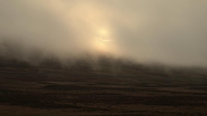 Lone car driving on mountain road under low clouds, Iceland.mov
