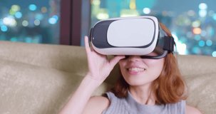 woman sit on sofa and wear virtual reality headset at home