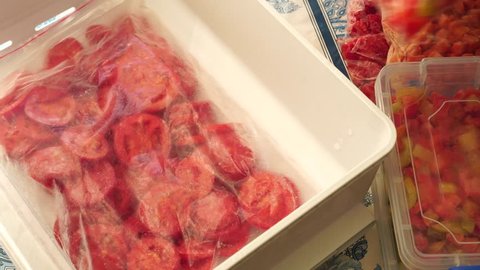 Cooking And Freezing Vegetables. Kitchen Organization. Woman puts bags of frozen food in the freezer