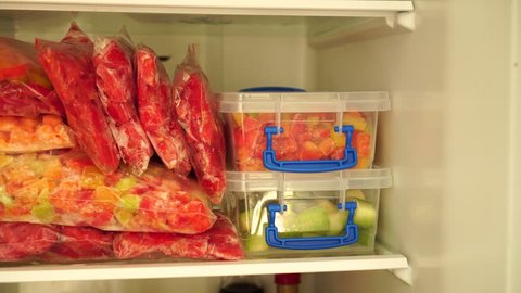 Freezing and Storing Fruits and Vegetables. Refrigerator. Packages and containers with frozen food