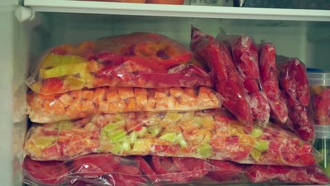 Freezing fruits and vegetables at home. Fridge Organization. Packages and containers with frozen food