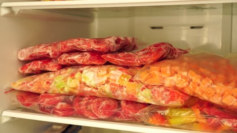 Fridge Organization. Packages and containers with frozen fruits and vegetables. Food storage