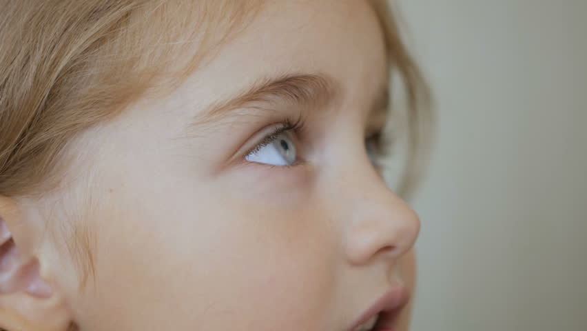 Portrait little young girl with blue eyes looking up. Closeup | Shutterstock HD Video #1017084625