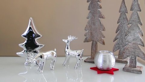Christmas decoration with toy deers, fir-trees and decorative candle and snow 
