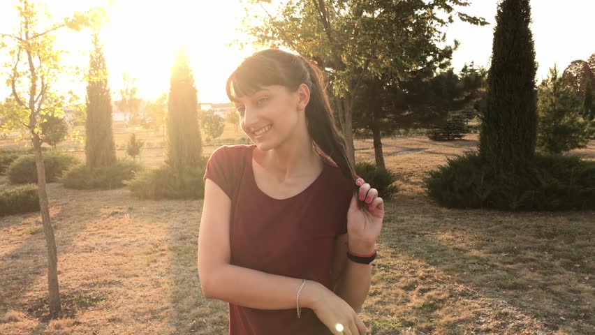 Beautiful caucasian model posing at sunset. Beautiful girl in the autumn park. Slow motion.