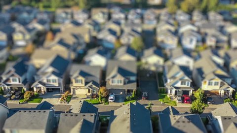 4k footage of an aerial view fly-over of an American suburban neighborhood; tilt-shift lens effect to make houses appear as tiny toy models