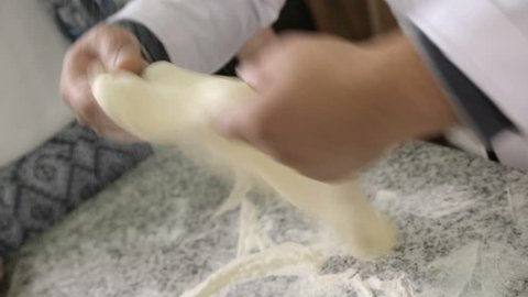 Skillful baker kneads dough and forms khachapuri, culinary traditions in Georgia