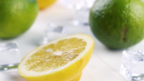 Lime and lemon with ice cubes on white background. Close up.
