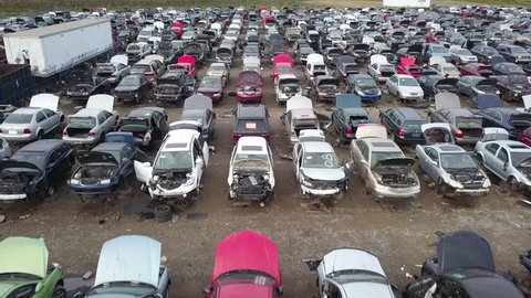 Aerial drone footage of a junk yard with row after row of wrecked cars.