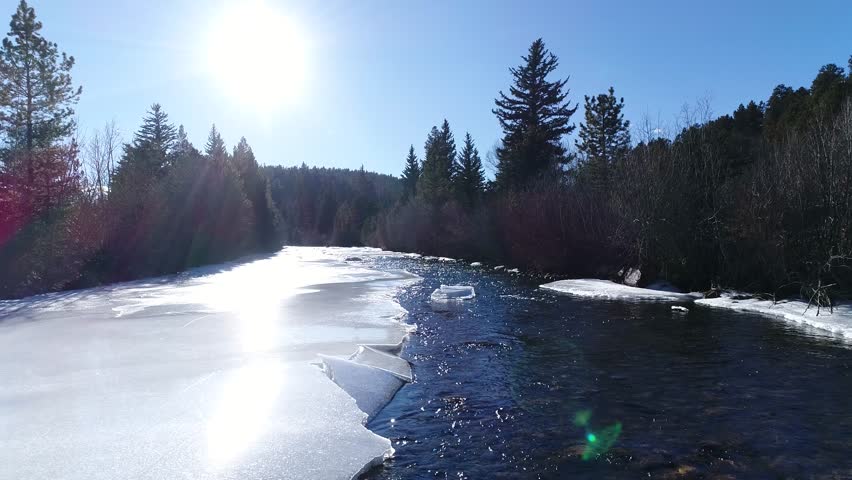 This is an aerial of a frozen river in Colorado during Winter.