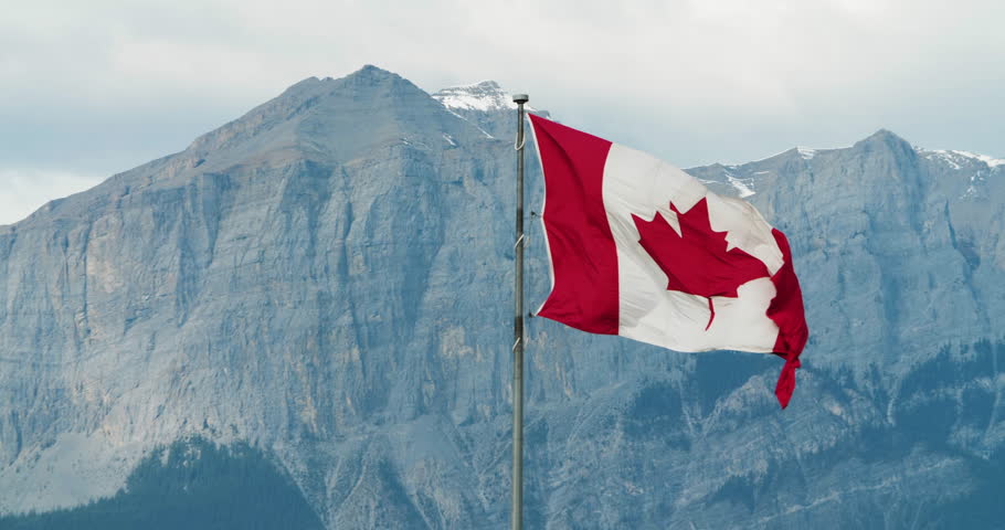 Canadian Flag Blowing in the Wind with Rocky Mountains in the Background, West Coast, Banff, Canmore, Alberta, Canada Royalty-Free Stock Footage #1017109018