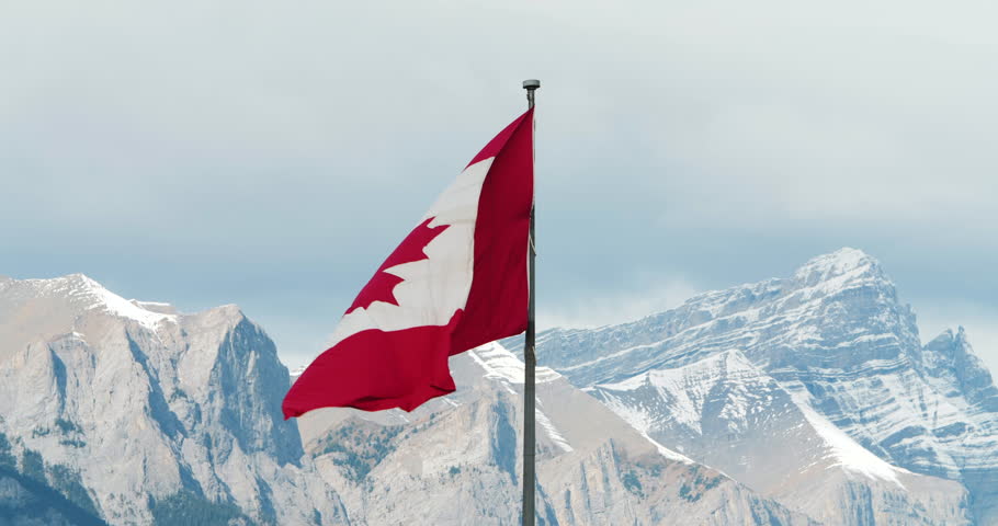 Canadian Flag Blowing in the Wind with Rocky Mountains in the Background, West Coast, Banff, Canmore, Alberta, Canada Royalty-Free Stock Footage #1017109030