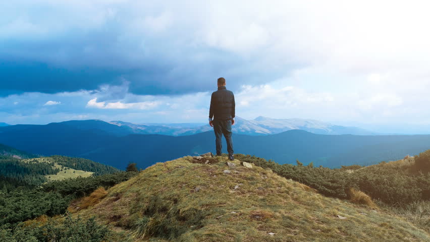 The male standing on the top of the mountain with a picturesque landscape Royalty-Free Stock Footage #1017111697