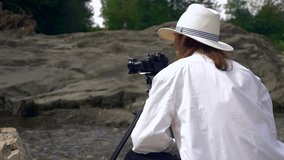 Close-up Videographer Shoots Footage On Rocks Near Mountain River. Filmmaker Camera Operator. Slow motion 4k 30p 0.5 speed of 60p