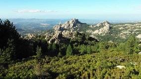 Video from above, aerial view of a beautiful valley surrounded by granite mountains and green vegetation, Monte Limbara, Sardinia, Italy.
