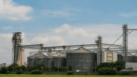 Industrial factory of animal feed storage and Blue sky with moving clouds. Video Time lapse 4k
