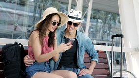 Travel. Couple Using Phone And Sitting Near Airport Terminal