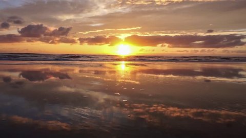 At the sea (North Sea in the Netherlands) the sun goes down. The surf casts waves. Cinemagraph with endless loop.
