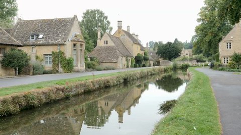 Gentle ripples on beautiful slow-moving River Eye running through the middle of Lower Slaughter. Lower Slaughter is a village in the English county of Gloucestershire, located in the Cotswold district