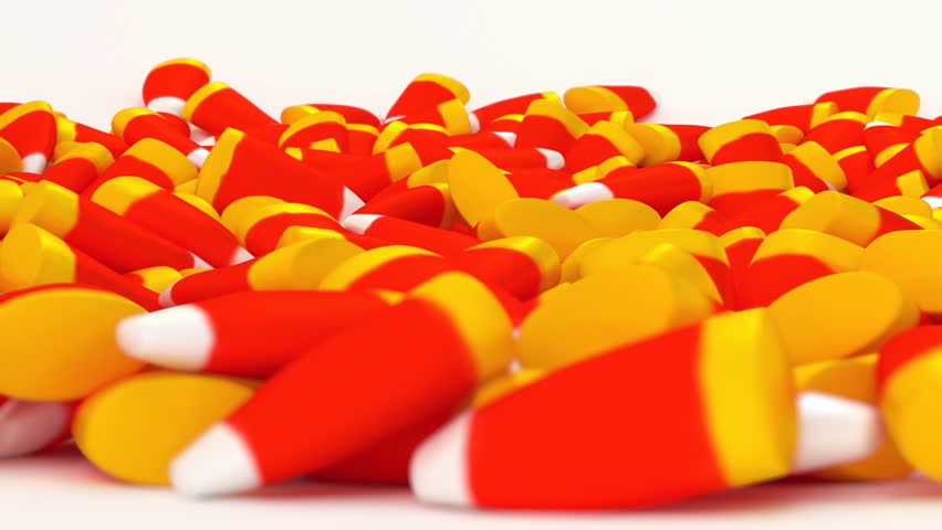 Animated rotating around pile of fallen Halloween white and red and yellow cone candies laying on white background or base.