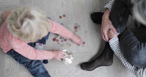 Overhead shot of grandmother helping grandchild count pocket money