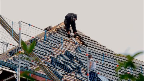 Dusseldorf, Germany -August 25,2016: Roofers laying tile on the roof