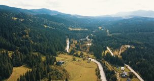 Beautiful drone footage of little forest town in Western Ukraine surrounded with high rocky Carpathian mountains and green forest on hills.Travel destination for active tourism in Southern Europe