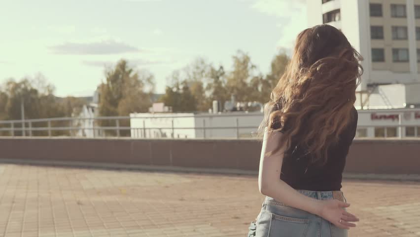 Portrait beautiful smiling girl have fun at sunset outdoors. Pretty female in slow motion. Looking at camera