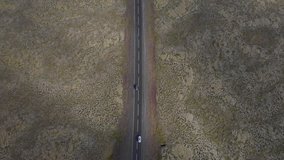 4k Drone Footage of cars driving on road in Iceland Scenery with Mountains and unique landscapes. Slow tilt upward pan