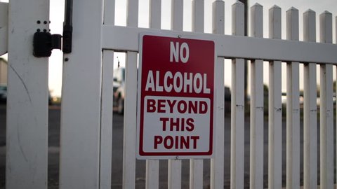No alcohol beyond this point sign on white fence.mov