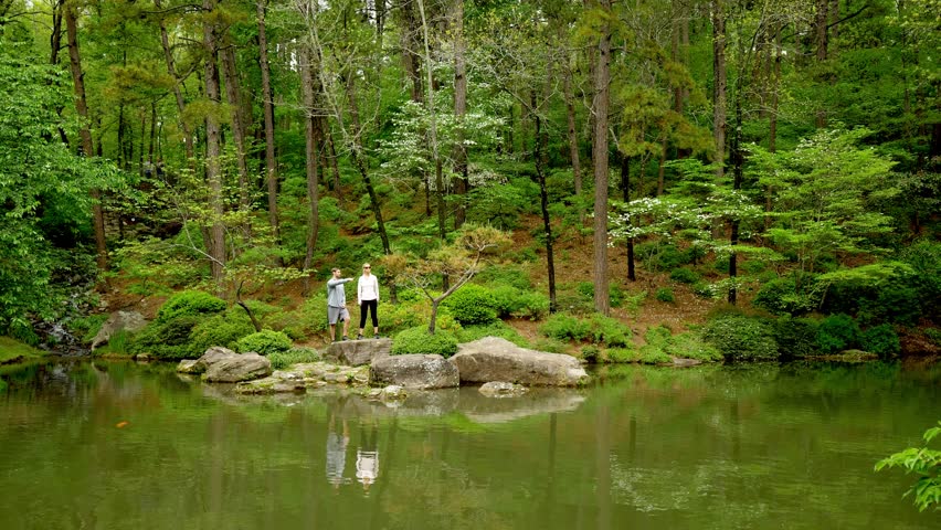 Couple Standing Across Beautiful Pond, Pointing, Slow-Motion