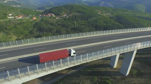 AERIAL: Flying above freight truck transporting the cargo on freeway