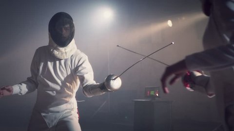 Footage video slow motion of two fencing athletes duel . Two Professional Fencers Show Masterful Swordsmanship in their Foil Fight. They Dodge, Leap and Thrust and Lunge . Shot on ARRI ALEXA in slow . : vidéo de stock